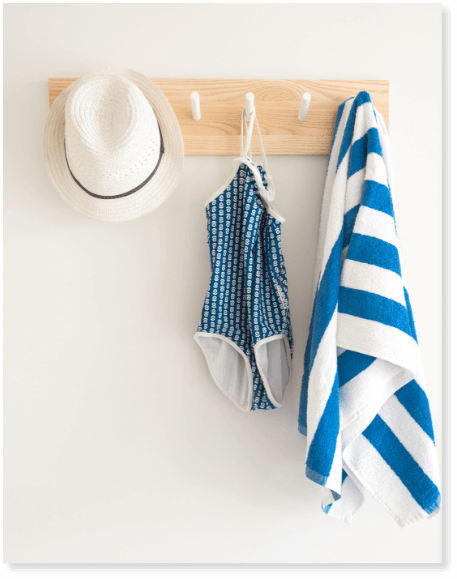 towel, swimsuit and hat hanging on wall hooks