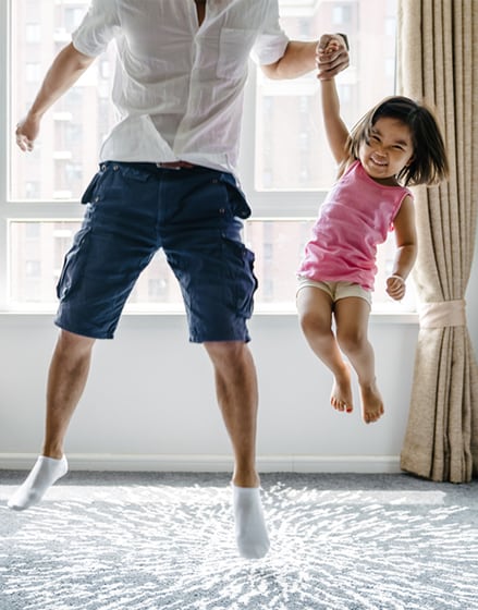 a father and daughter jumping in the air
