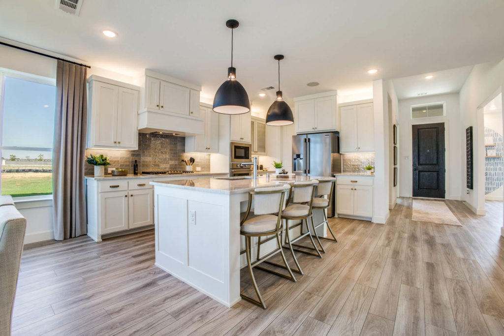 A Texas kitchen with white cabinets and hardwood floors in a new home.