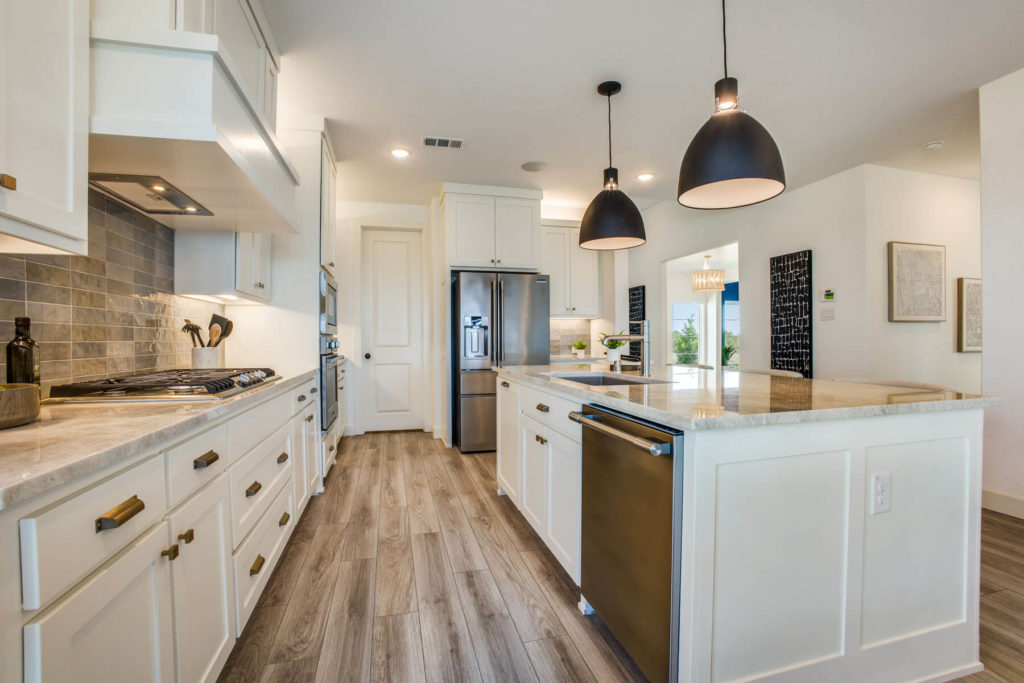 A nature-inspired kitchen with white cabinets and wood floors nestled in the McKinney Trails.