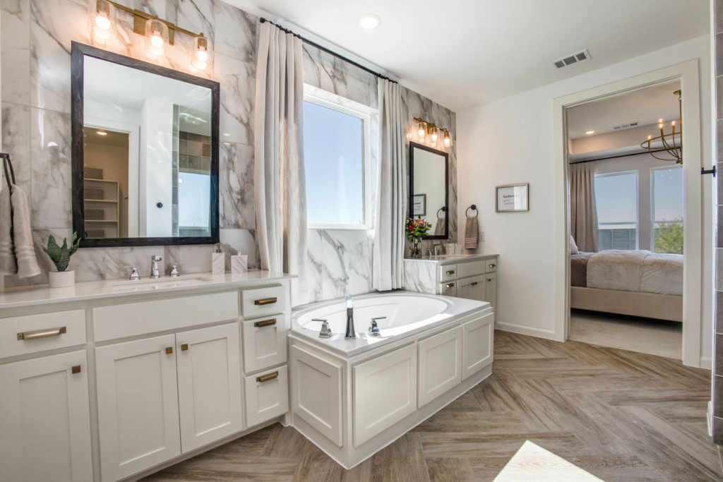 A large bathroom with marble floors and a large tub, inspired by the natural beauty of Texas.