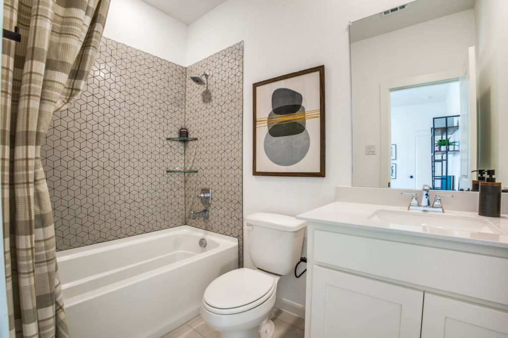 A bathroom in McKinney that features a toilet, sink, and shower.