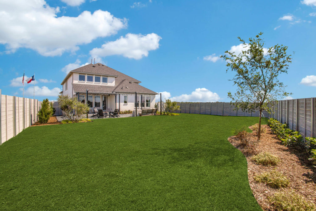 A backyard in McKinney, Texas featuring artificial grass and a fence.