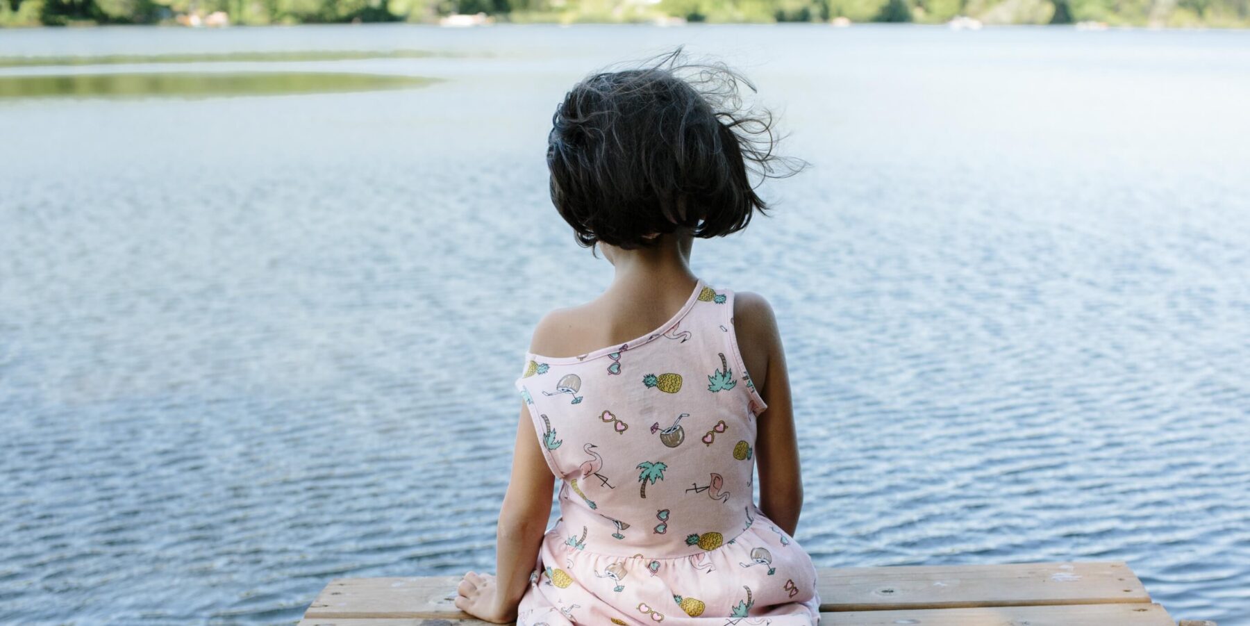 a young girl sitting on a dock