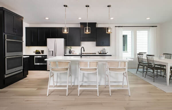 A modern kitchen with black cabinets and crisp white counter tops, perfect for new homes in McKinney, Texas.