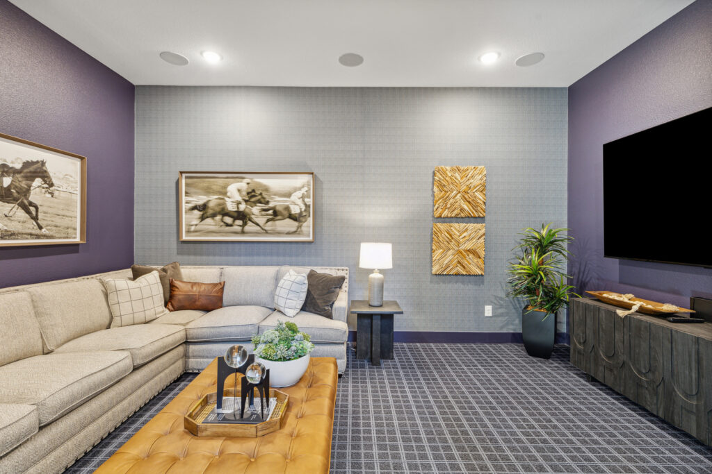 A living room with purple walls and a tv.