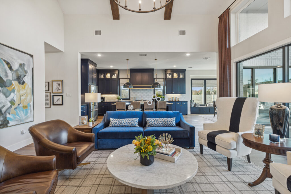 A living room with blue couches and a chandelier.