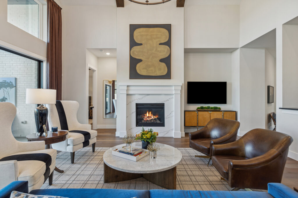 A living room with blue couches and a fireplace.
