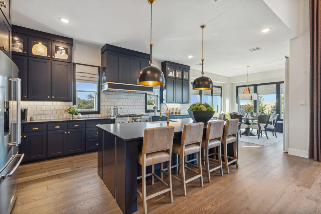 A kitchen with black cabinets and a center island.