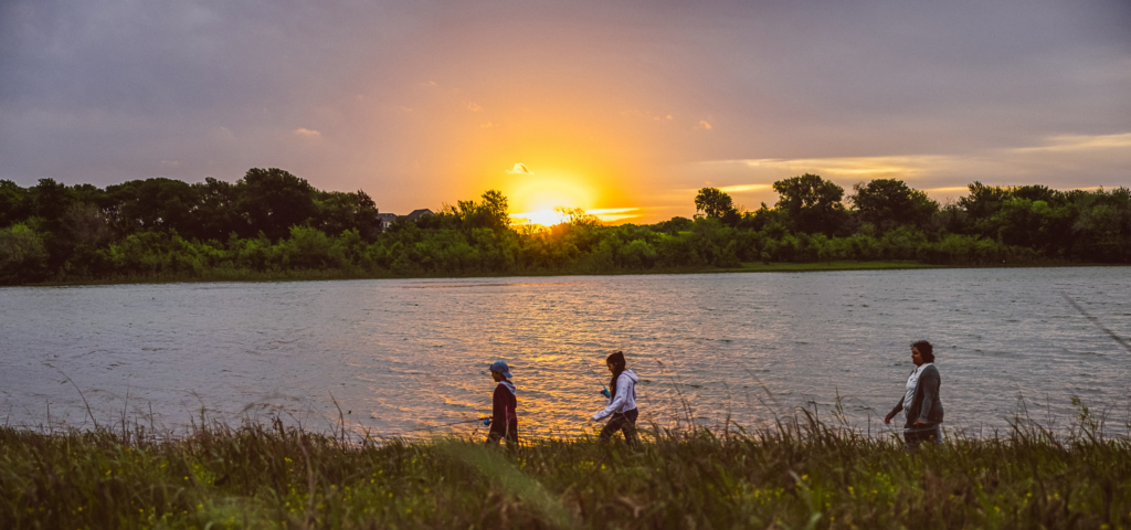 a family walking near Painted Tree lake at sunset