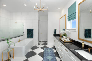 Modern bathroom in a new home for sale by Drees Custom Homes in McKinney, TX, featuring a freestanding bathtub, double-sink vanity, black and white checkered floor, gold fixtures, and striking teal accents.