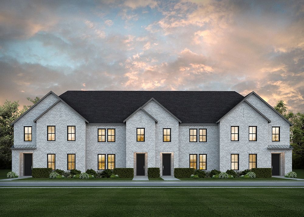A row of modern two-story townhouses with white brick exteriors, dark roofs, and illuminated windows at dusk—discover the charm of Painted Tree homes for sale set against a cloudy Texas sky.