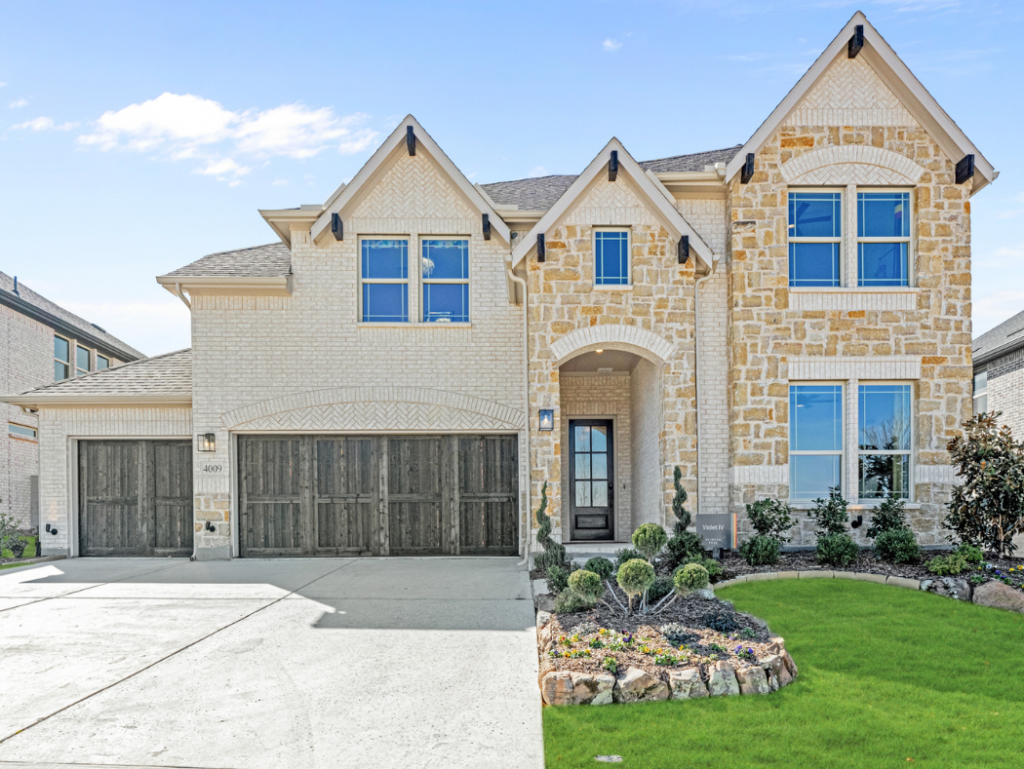 Charming two-story house in McKinney, TX, with a light brick and stone exterior, three-car garage, and a well-kept front yard featuring lush green grass and small shrubs. Perfect new home for sale.