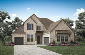 Two-story brick house with multiple gables, black garage doors, and a landscaped yard with shrubs and pink flowers—this charming property in Painted Tree McKinney is set against a blue sky, perfect for those seeking homes for sale in McKinney Texas.
