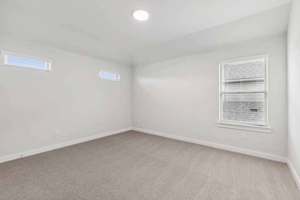 Empty room with beige carpet, white walls, three windows with blinds, and a ceiling light—ready for your touch in sought-after Painted Tree McKinney. Explore Painted Tree homes for sale and discover comfortable living in this vibrant community.