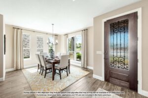 Bright dining room with a rectangular table, six chairs, large windows, light walls, and a dark wooden front door with decorative glass—perfect for those seeking homes for sale in McKinney Texas or the welcoming Painted Tree McKinney community.