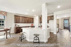 Spacious kitchen with dark wood cabinets, white countertops, a central island with bar stools, and adjacent dining area; enjoy this modern, open layout with wood flooring in sought-after Painted Tree McKinney.