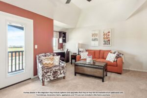Living room in Painted Tree McKinney with an orange sofa, patterned armchair, wooden coffee table, and desk near a window with balcony access. Neutral walls display sports-themed wall art—discover more homes for sale in McKinney, Texas.