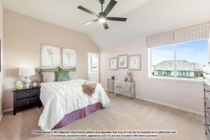 A bedroom in Painted Tree McKinney features a large bed, nightstands, wall art, a ceiling fan, and two windows letting in natural light—perfect for those seeking homes for sale in McKinney, Texas.