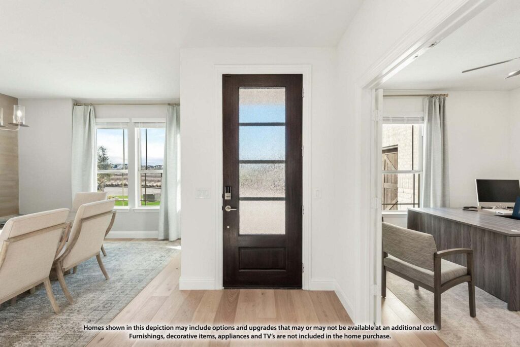 A modern entryway with a dark wooden door, adjacent to a bright living area with armchairs and a separate office space—perfect for those exploring homes for sale in McKinney, Texas or seeking inspiration at Painted Tree McKinney.