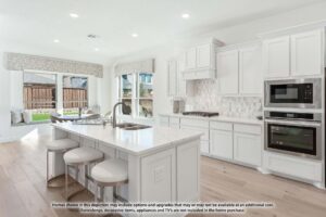 Modern white kitchen with island seating, built-in ovens, and large windows overlooking a fenced backyard in Painted Tree McKinney. Note: some items may not be included in the home purchase. Explore homes for sale in McKinney Texas.