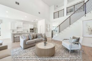 Modern living room with neutral-toned furniture, a round coffee table, open kitchen in the background, and a staircase with metal railings—perfect for those seeking homes for sale in McKinney, Texas, near Painted Tree.