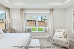 Bright bedroom with a large window seat, neutral decor, and an upholstered chair, overlooking a fenced backyard with neighboring houses—perfect for those exploring homes for sale in McKinney Texas.