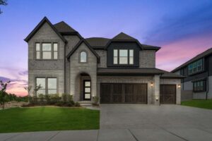 Two-story modern stone house with dark trim, large windows, and three-car garage in Painted Tree McKinney, set against a sunset sky with a manicured lawn and driveway—discover exceptional homes for sale in McKinney Texas.