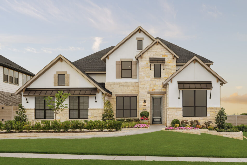 Two-story suburban house in McKinney's Painted Tree community with stone and white siding exterior, black trim, front lawn, small shrubs, and flower beds—a true TX gem.