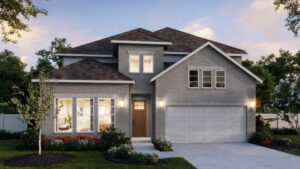 Two-story suburban house with gray brick exterior, double garage, front lawn, and large windows—this Normandy Homes gem in Painted Tree glows warmly at dusk, showcasing the appeal of new homes in a welcoming community.